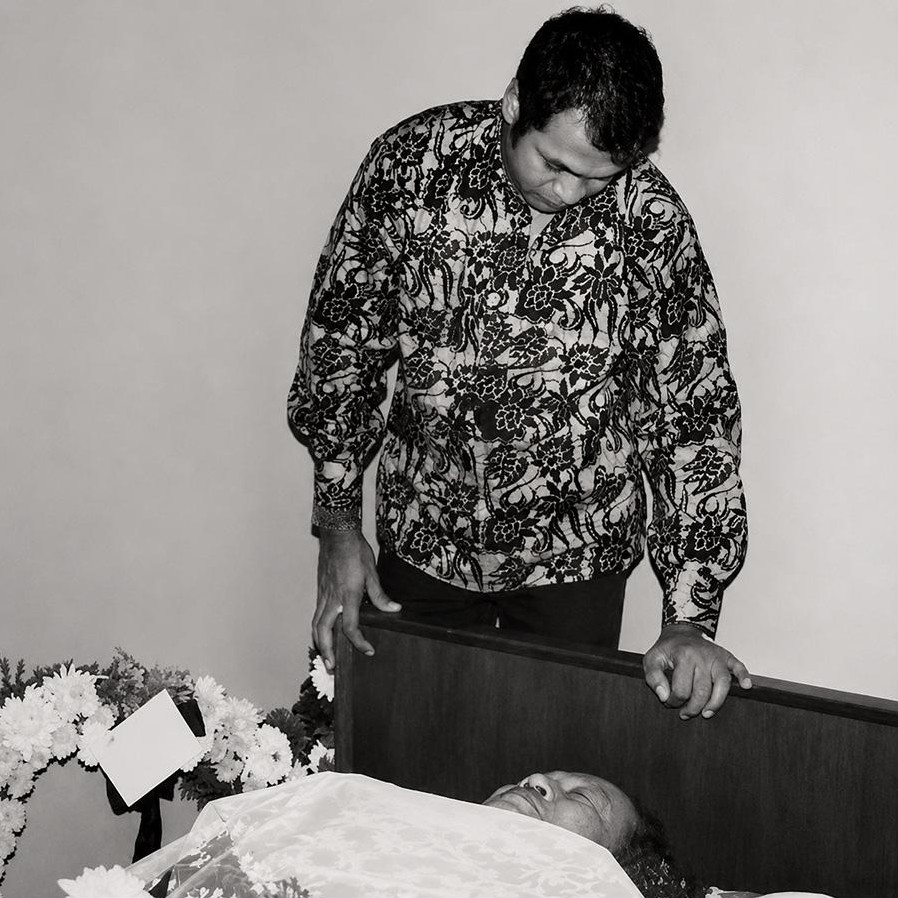 Jins Shamsuddin standing beside P. Ramlee lying in state, 1973