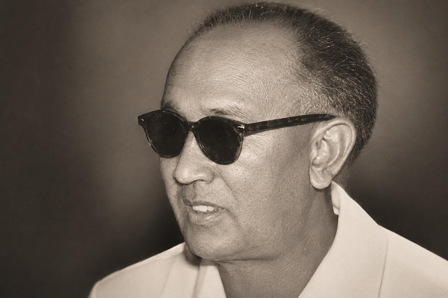 A studio figure in dark glasses