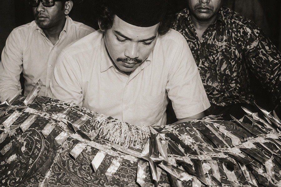 Nasir P. Ramlee seated beside his father lying in state, 1973