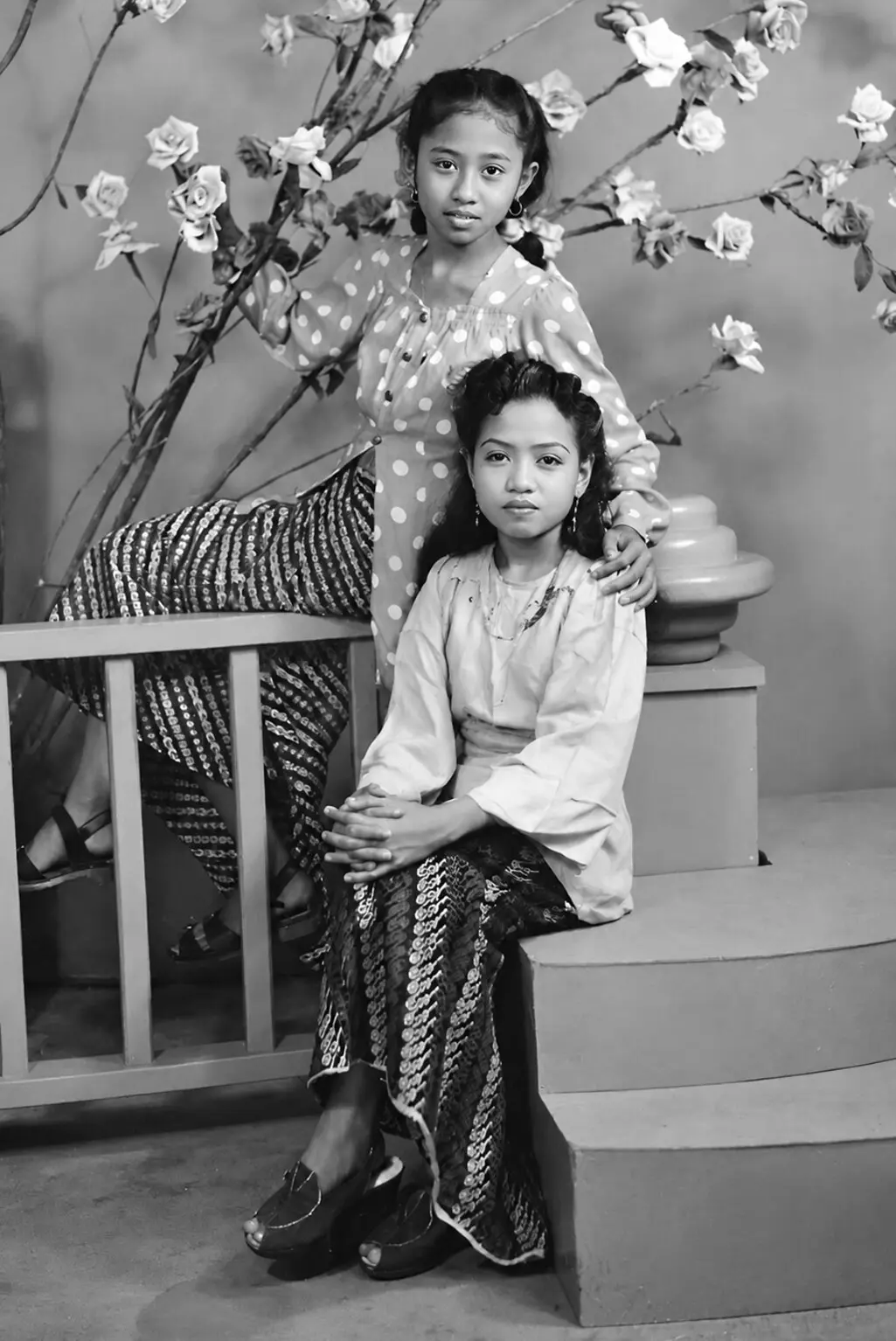 Black-and-white studio portrait of two young girls