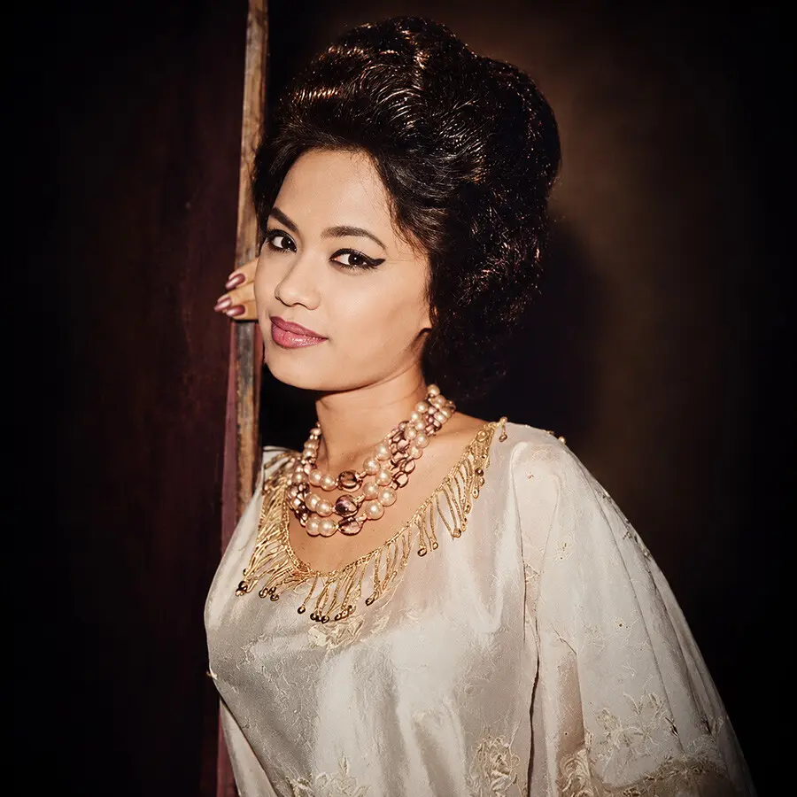 Colour studio portrait of Saloma in a cream embroidered blouse and pearl necklace